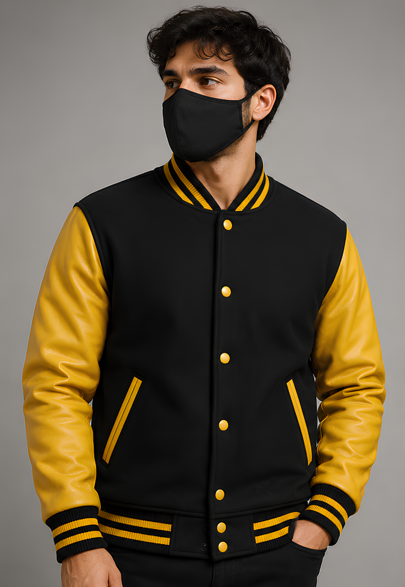 Person wearing a black and yellow varsity jacket with a gray background