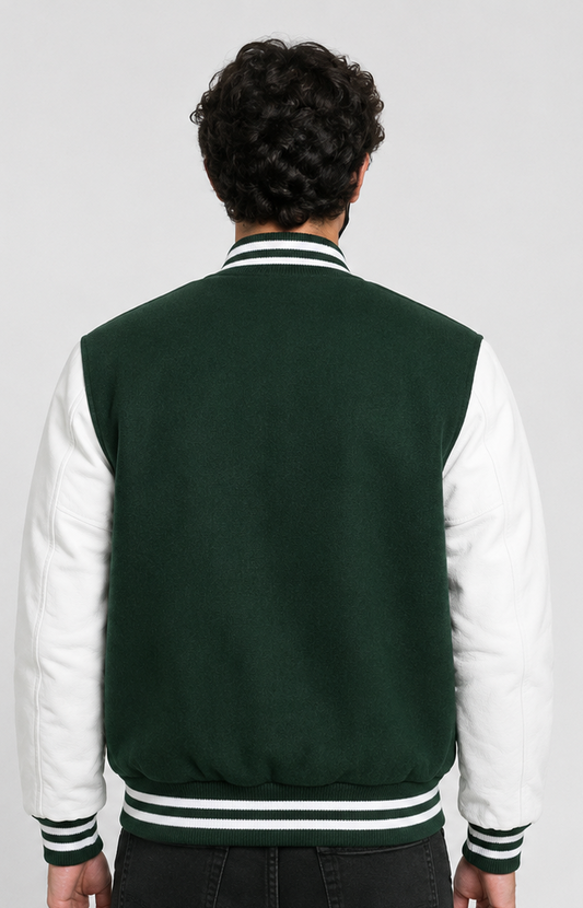 Person wearing a dark green and white varsity jacket on a plain background