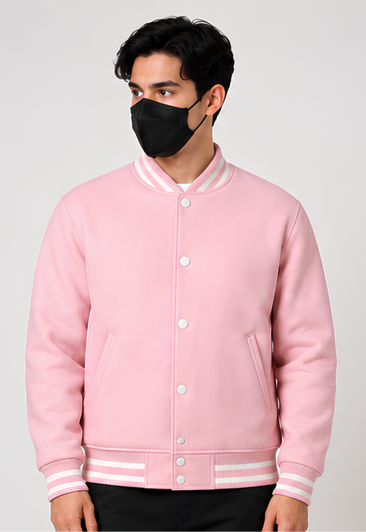 Person wearing a pink varsity jacket and black face mask on a light gray background