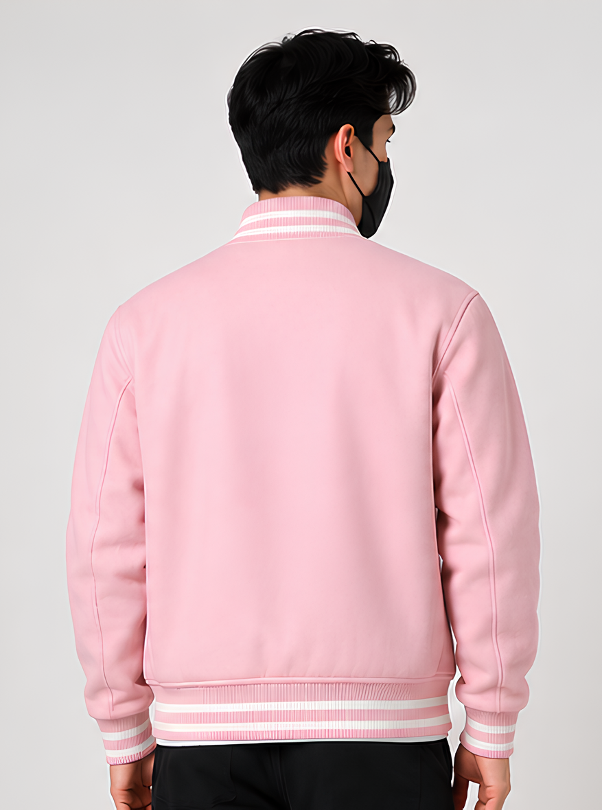Person wearing a pink varsity jacket on a plain background
