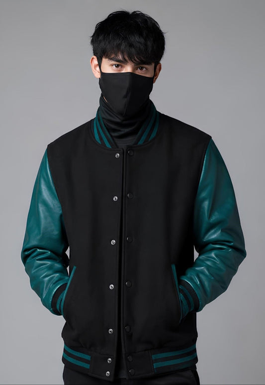 Person wearing a black and teal varsity jacket with a face mask on a gray background