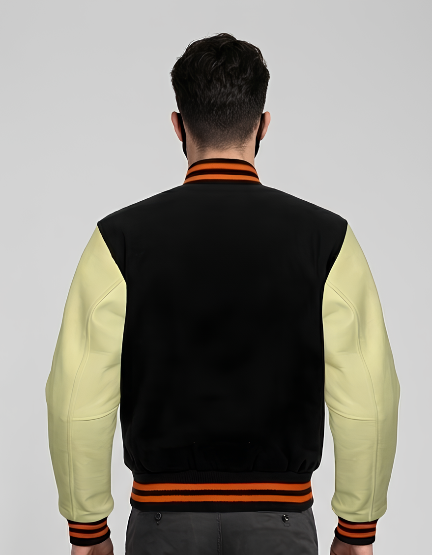 Person wearing a black and cream varsity jacket with orange accents on a gray background