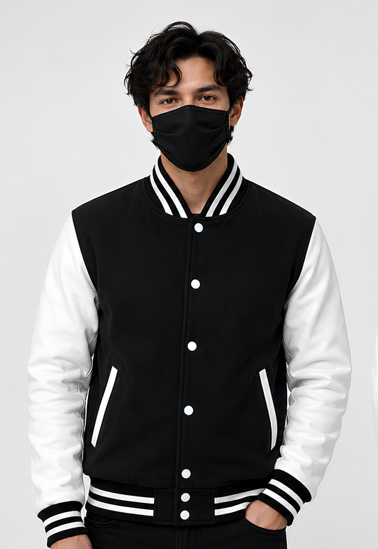 Person wearing a black and white varsity jacket with a plain background