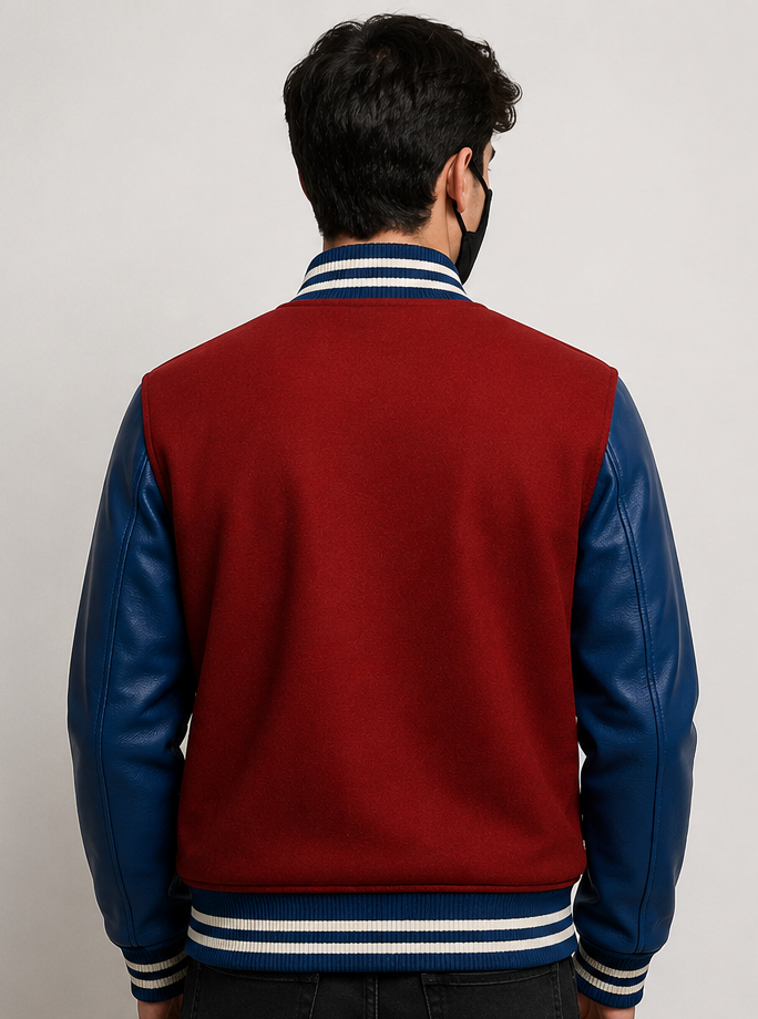 Person wearing a red and blue varsity jacket with a plain background