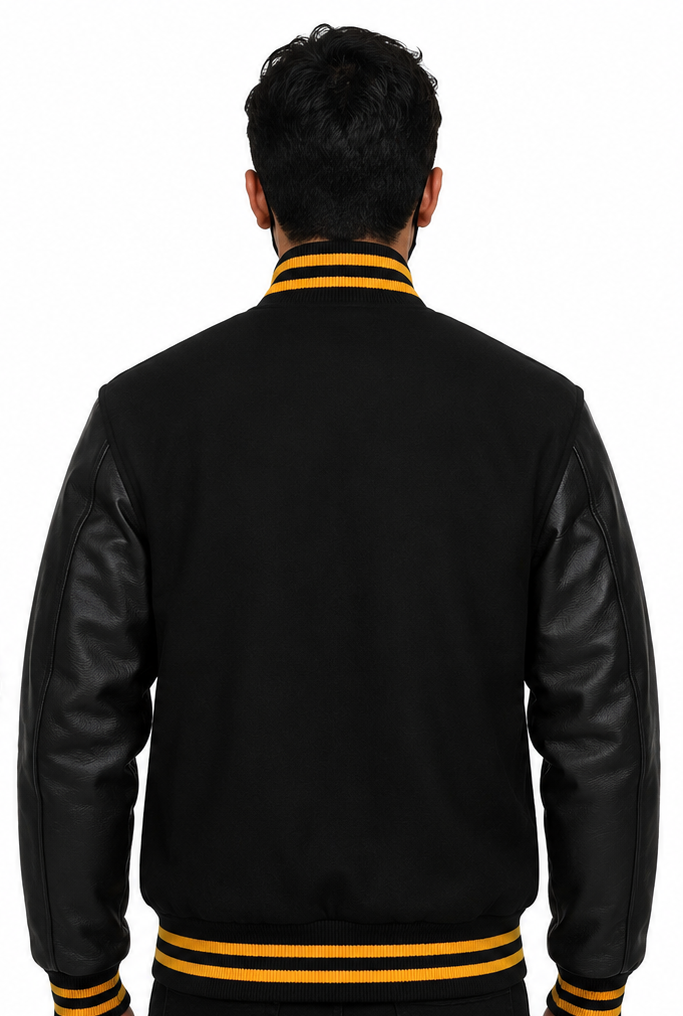Person wearing a black varsity jacket with yellow accents on a white background